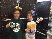 Two children holding crafts they made at a library program