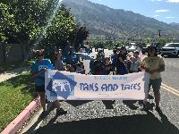 People marching in a parade holding a sign