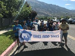 People marching in a parade holding a sign