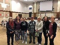 8 people standing in front of a used book sale