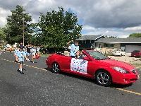 People in a red convertible in a parade