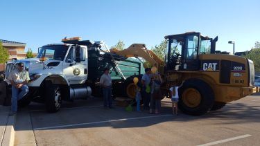 People looking at construction vehicles